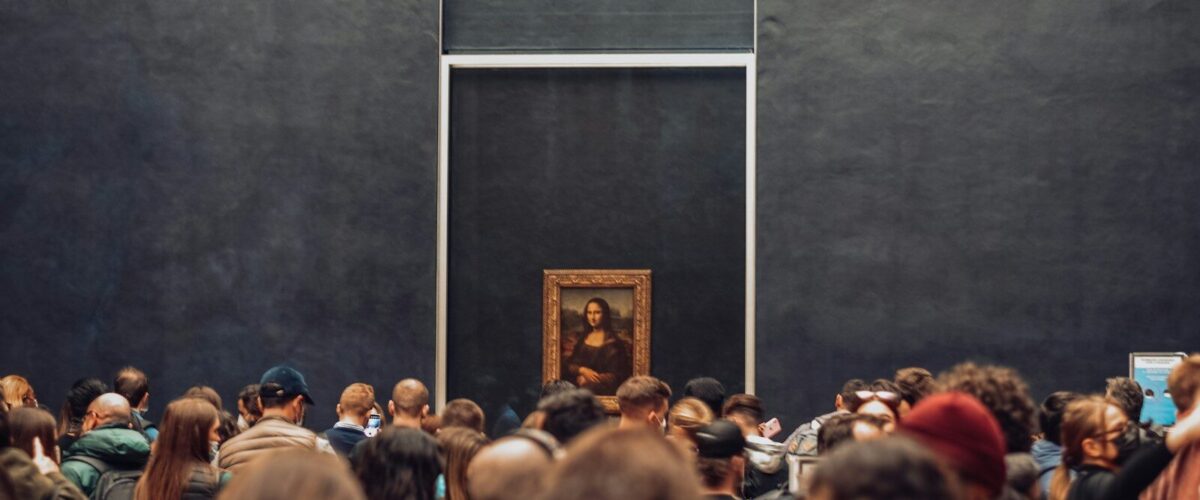 a crowd of people standing in front of a painting